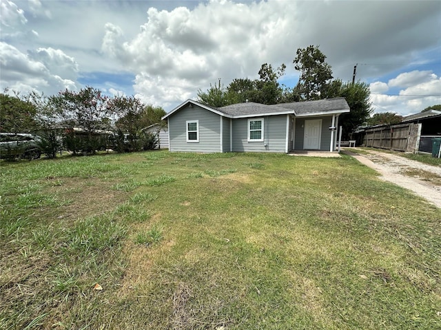 ranch-style house with fence and a front lawn