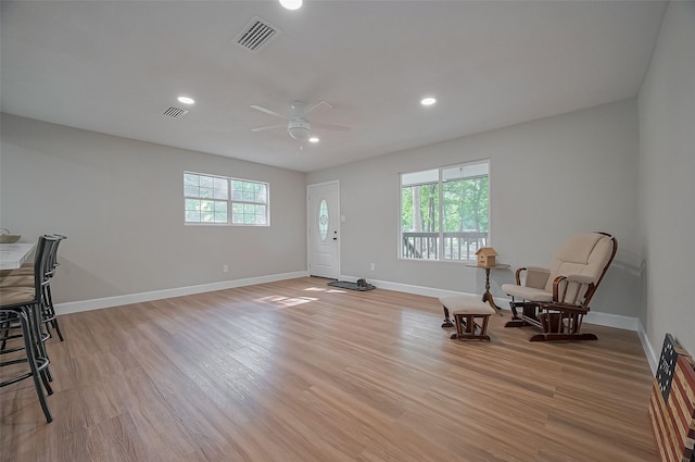 sitting room featuring visible vents, a ceiling fan, light wood finished floors, and baseboards