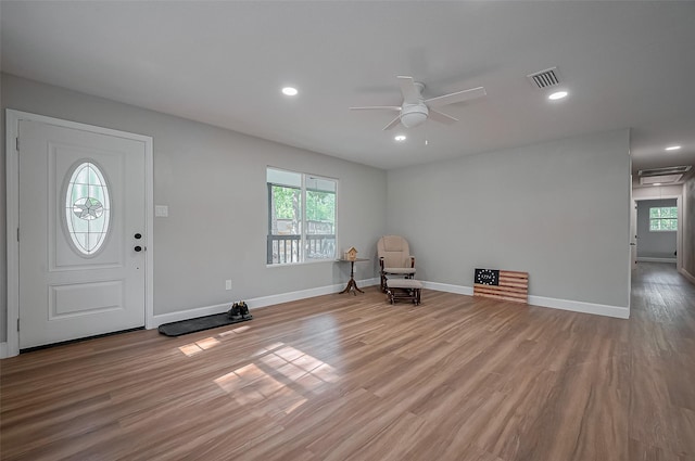 foyer entrance with a ceiling fan, visible vents, a wealth of natural light, and wood finished floors