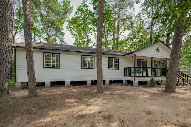 rear view of property featuring a shingled roof