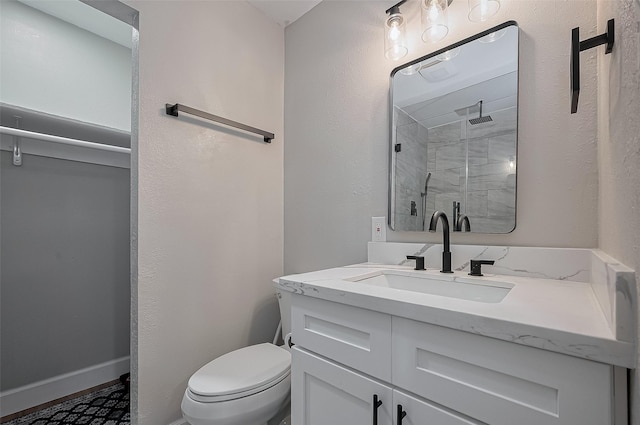 full bath with toilet, a shower stall, vanity, and baseboards