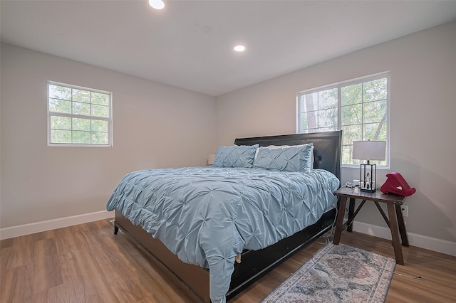 bedroom featuring wood finished floors, recessed lighting, and baseboards