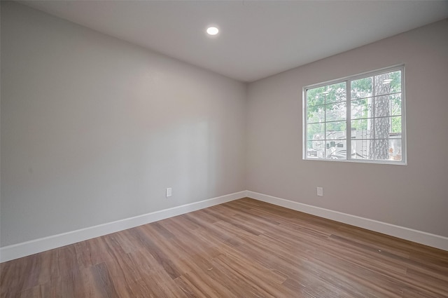 unfurnished room with recessed lighting, light wood-style floors, and baseboards