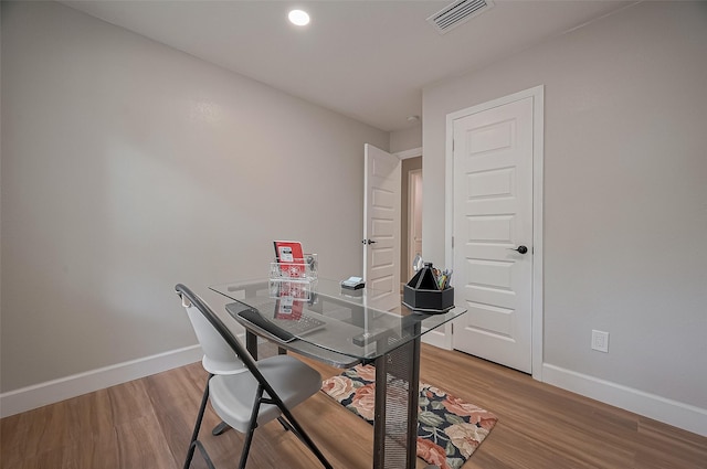 office space featuring light wood finished floors, visible vents, and baseboards