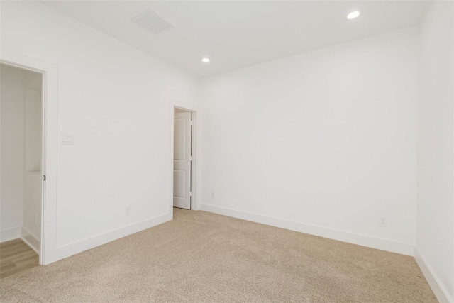 spare room featuring recessed lighting, visible vents, and light carpet