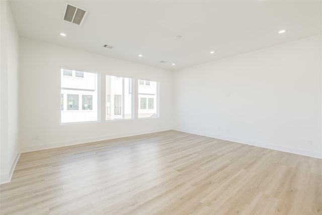 spare room with recessed lighting, light wood-style flooring, and visible vents