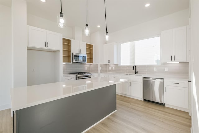 kitchen featuring open shelves, white cabinetry, a sink, backsplash, and stainless steel appliances