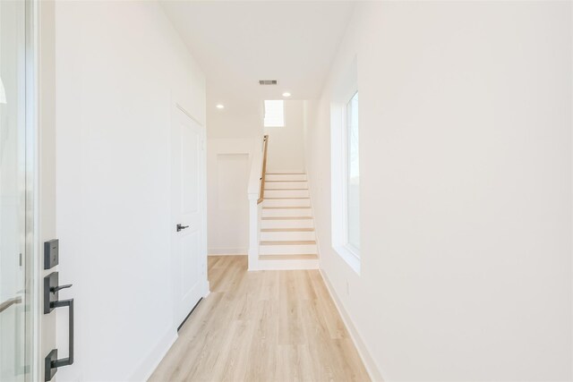 hallway with light wood-style floors, recessed lighting, baseboards, visible vents, and stairway