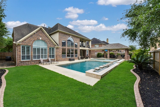back of house featuring a gazebo, a balcony, a fenced backyard, and brick siding