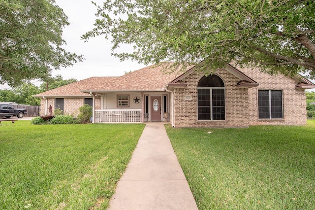 ranch-style home with a porch, brick siding, and a front yard