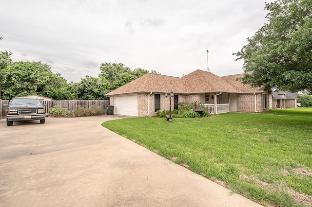 ranch-style home with fence, an attached garage, brick siding, a front yard, and driveway