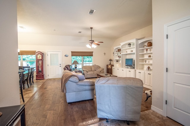 living room featuring a ceiling fan, dark wood-style floors, and visible vents