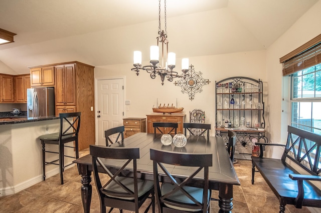dining room with tile patterned flooring, an inviting chandelier, and lofted ceiling