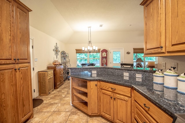 kitchen with brown cabinets, a peninsula, and dark stone counters