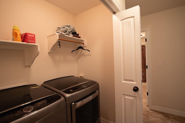 clothes washing area featuring laundry area, washer and clothes dryer, and baseboards