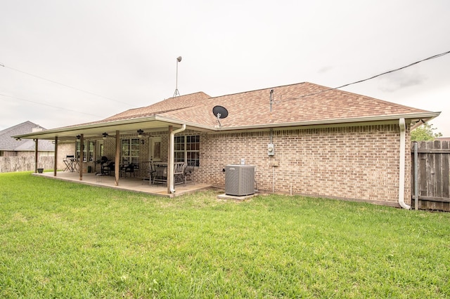 back of property with fence, ceiling fan, central AC, and brick siding
