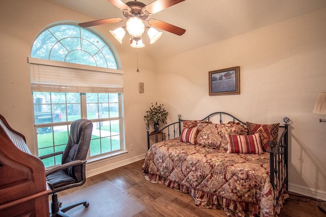 bedroom with baseboards, multiple windows, wood finished floors, and lofted ceiling