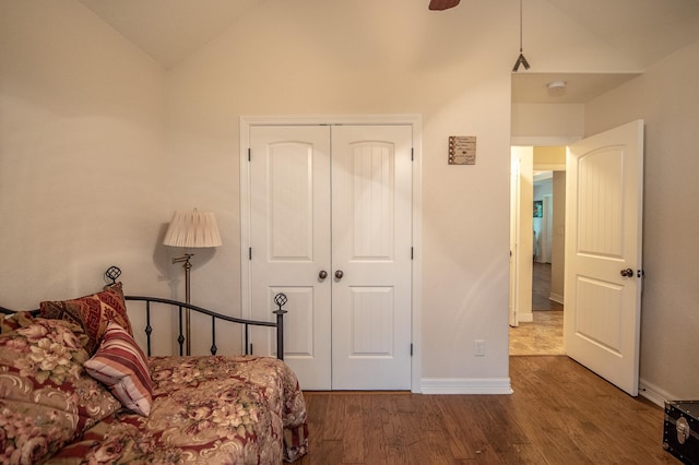 bedroom featuring a ceiling fan, baseboards, wood finished floors, lofted ceiling, and a closet