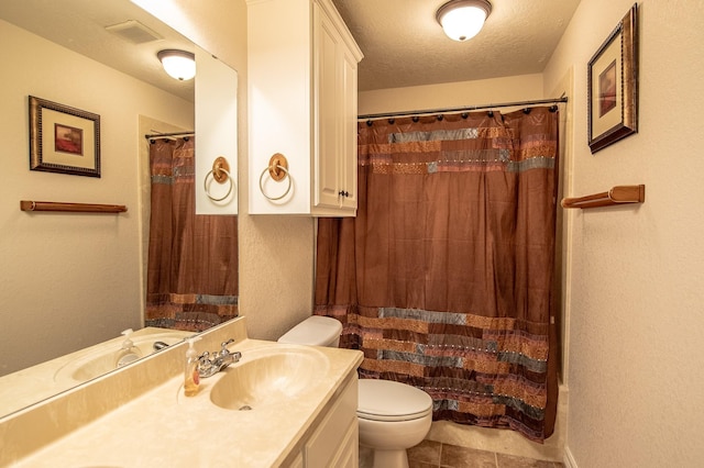 bathroom with tile patterned flooring, vanity, toilet, a textured ceiling, and visible vents