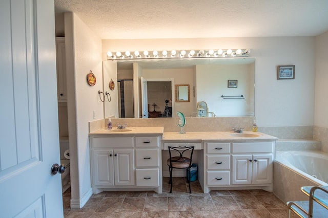 bathroom with double vanity, a sink, and a garden tub