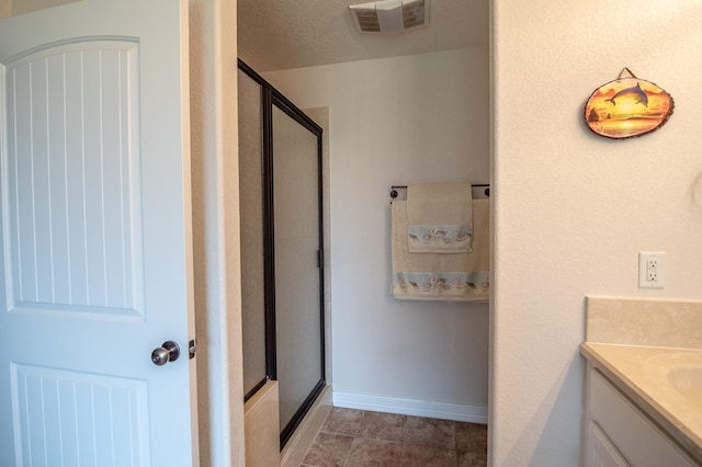 bathroom with vanity, baseboards, visible vents, and a stall shower