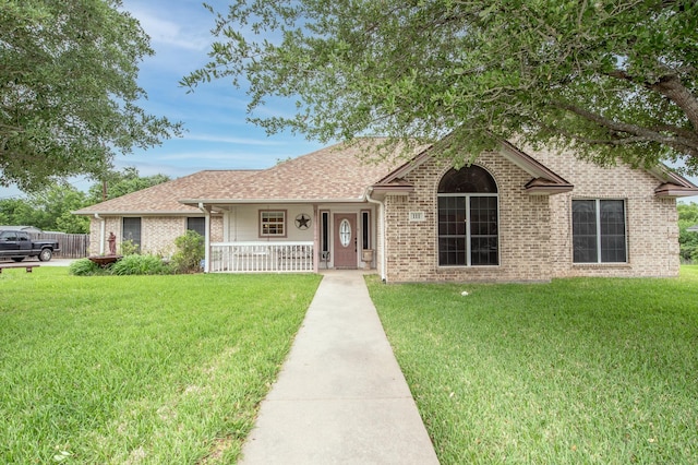 ranch-style home with a porch, brick siding, and a front yard