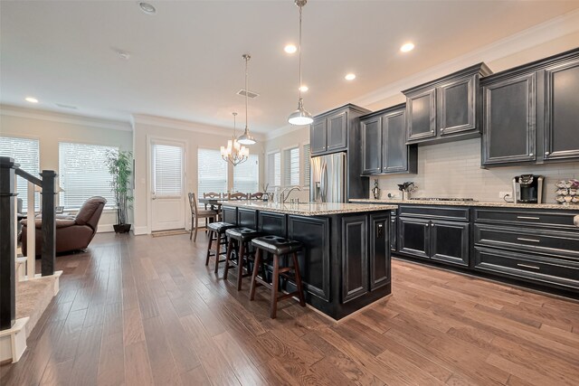 8820 Ashbloom Ln, Houston, TX 77080 - kitchen with stainless steel appliances, dark cabinets, crown molding, a breakfast bar area, and a chandelier
