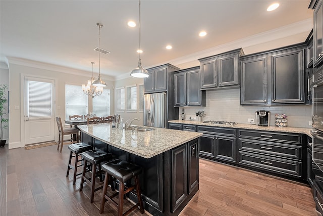 8820 Ashbloom Ln, Houston, TX 77080 - kitchen with stainless steel appliances, light wood-type flooring, ornamental molding, dark cabinets, and tasteful backsplash
