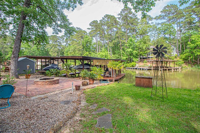 70 Lower Cove Dr, Point Blank, TX 77364 - view of grassy yard with an outdoor fire pit, a deck with water view, view of scattered trees, and a patio