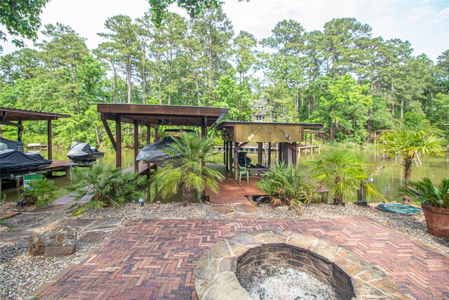 70 Lower Cove Dr, Point Blank, TX 77364 - view of patio with boat lift, a dock, a fire pit, and view of wooded area