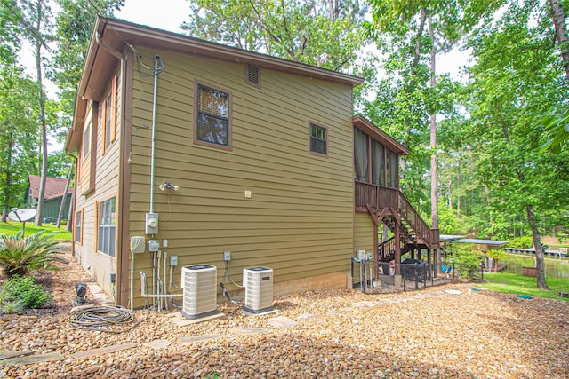 70 Lower Cove Dr, Point Blank, TX 77364 - view of side of property with central AC unit, stairway, and a sunroom