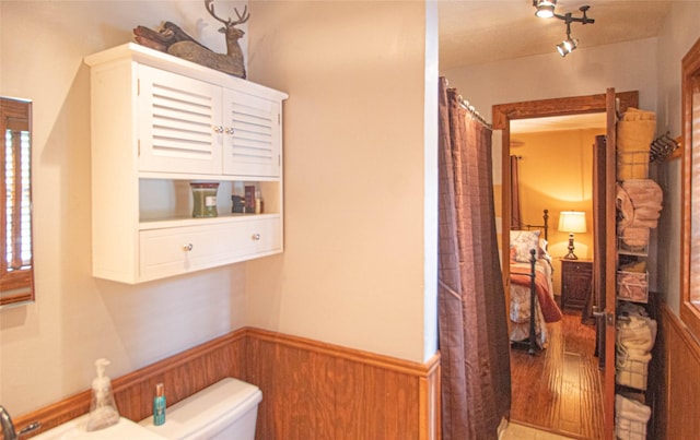 70 Lower Cove Dr, Point Blank, TX 77364 - full bathroom featuring toilet, wainscoting, and curtained shower