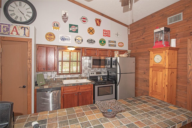 70 Lower Cove Dr, Point Blank, TX 77364 - kitchen featuring stainless steel appliances, a sink, tile countertops, tasteful backsplash, and wooden walls