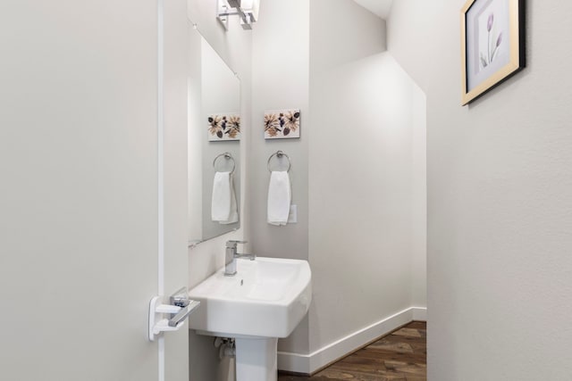 half bath with wood finished floors and baseboards