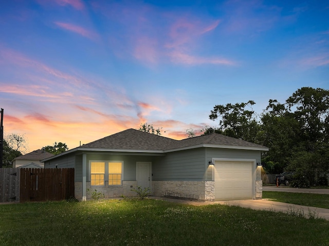 ranch-style house featuring a yard, stone siding, a garage, and fence