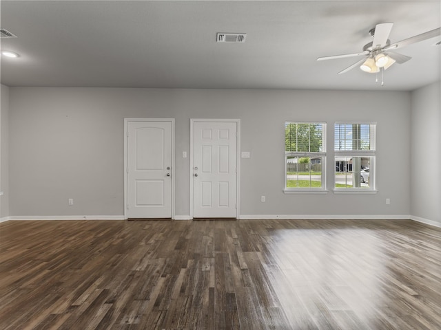 spare room with baseboards, visible vents, a ceiling fan, and dark wood-type flooring