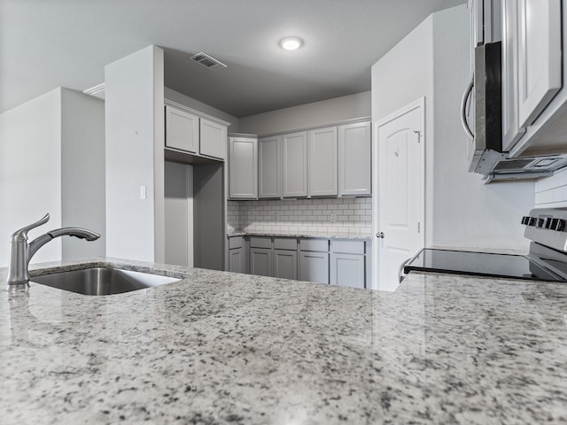 kitchen featuring visible vents, a sink, stainless steel appliances, and decorative backsplash