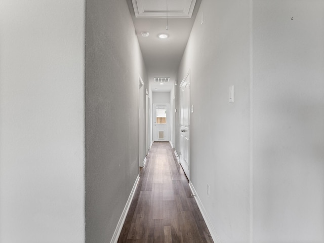 corridor with attic access, visible vents, dark wood-style flooring, and baseboards