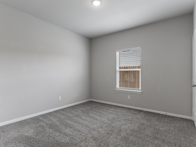 unfurnished room featuring carpet flooring and baseboards