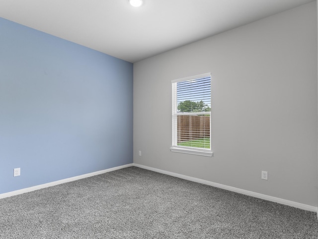 carpeted spare room featuring baseboards
