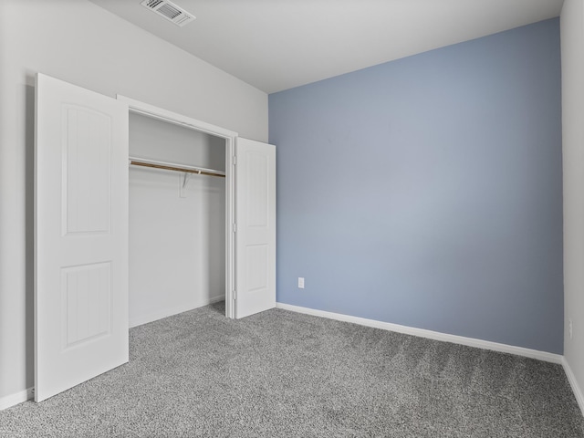 unfurnished bedroom with a closet, carpet flooring, baseboards, and visible vents