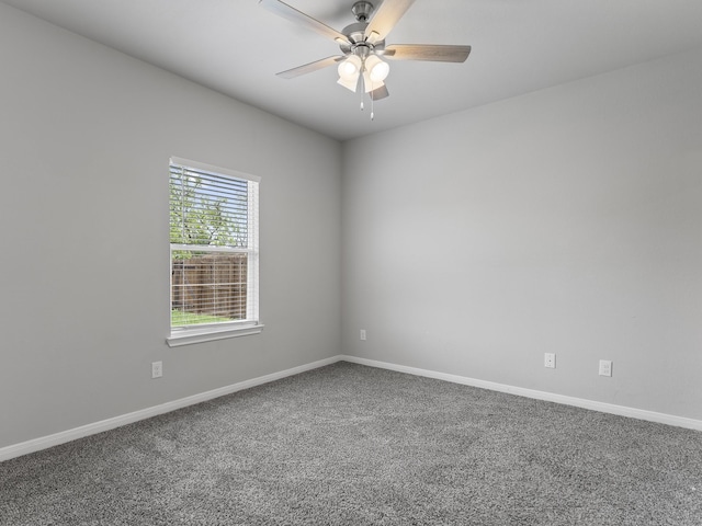 carpeted empty room featuring a ceiling fan and baseboards