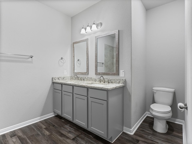 full bathroom with wood finished floors, toilet, and a sink