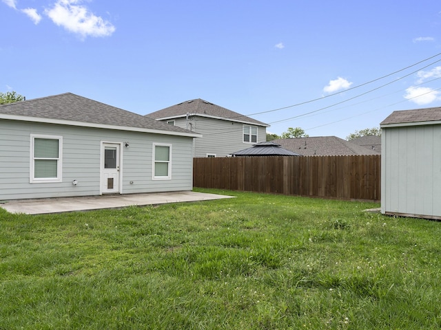 back of property with fence, a patio area, and a lawn