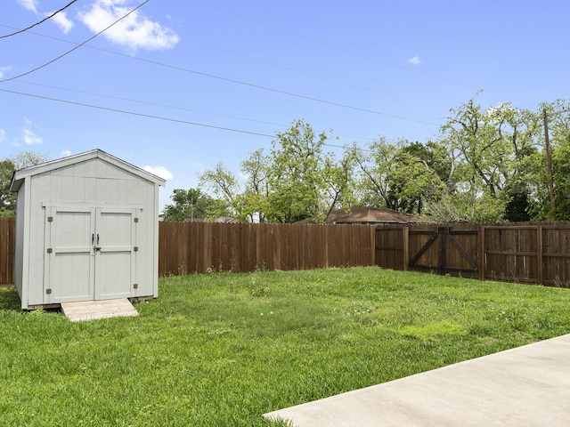 view of yard featuring an outdoor structure, a storage shed, and a fenced backyard