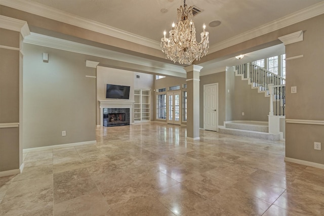 unfurnished living room with a chandelier, decorative columns, a premium fireplace, baseboards, and crown molding