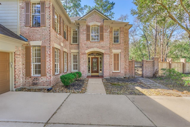 traditional-style home with brick siding, fence, and driveway