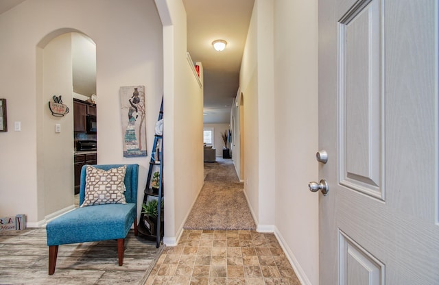 10255 Scenic Vista Dr, Humble, TX 77396 - corridor featuring baseboards, stone finish flooring, and arched walkways