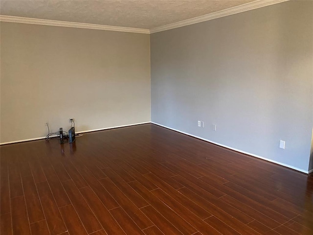 spare room featuring dark wood-style floors, baseboards, ornamental molding, and a textured ceiling