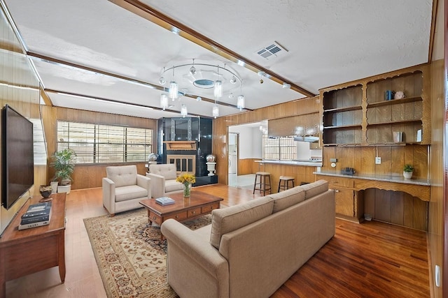 7718 Pella Dr, Houston, TX 77036 - living area with visible vents, wood walls, and wood finished floors